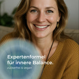 Frau blickt lächelnd in die Kamera. Text im Bild: ‚Expertenformel für innere Balance. Zuckerfrei und vegan